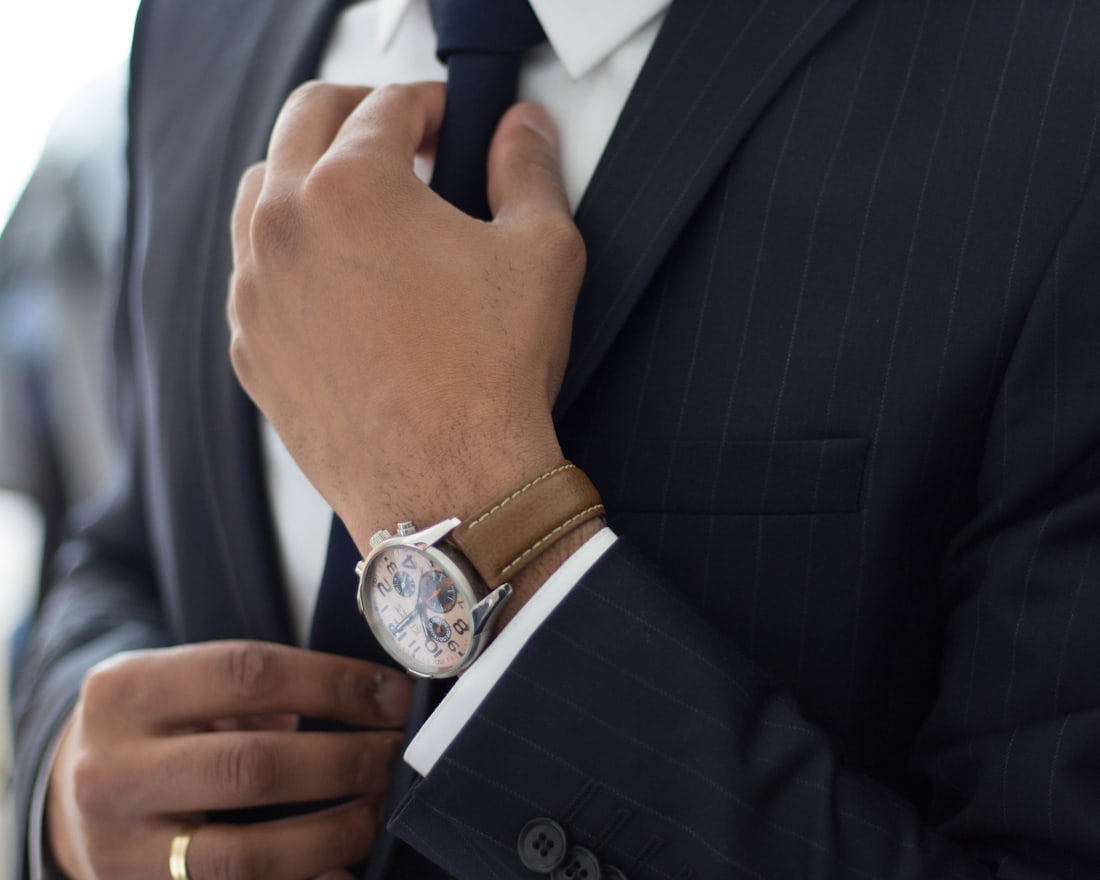 Ejecutivo ajustando su reloj antes de un traslado con servicio de protección personal